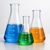 Three conical Erlenmeyer flasks of different sizes with graduations, holding blue, green and orange liquids